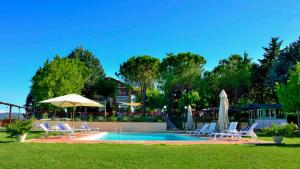 uma piscina com espreguiçadeiras e guarda-sóis em Agriturismo Rivoli em Spoleto