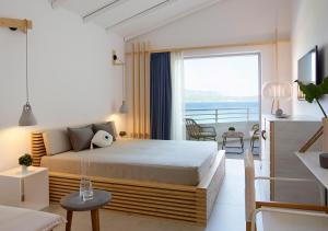 a bedroom with a bed and a view of the ocean at Proteas Blu Resort in Pythagoreio