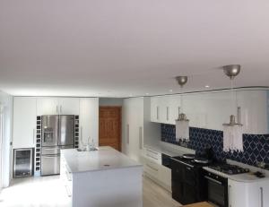 uma grande cozinha com electrodomésticos brancos e armários pretos em Five Oaks em Derry Londonderry