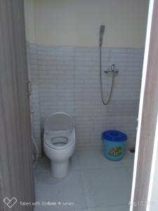 a white bathroom with a toilet and a shower at Rumah Sakinah in Wonosobo