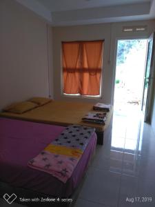 a small bedroom with a bed and a window at Rumah Sakinah in Wonosobo