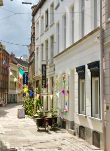 a street with flags and buildings on a city street at Bennestay in Ghent