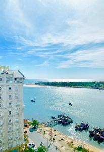 a building next to a body of water with boats at CKC Thien Duong Hotel in Dong Hoi