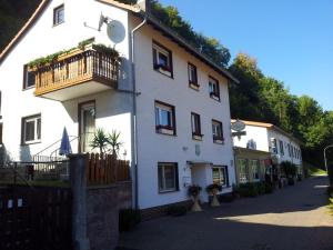 Un edificio blanco con un balcón al costado. en Landgasthof Zum Heiligenberg, en Sontra