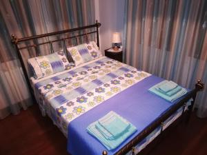 a bedroom with a bed with blue sheets and pillows at Traditional Maisonette In Pelion in Volos
