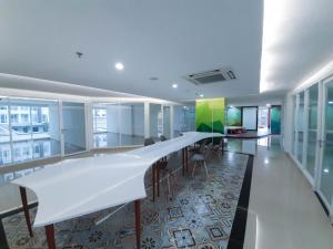 an office with a long white table and chairs at Apartemen Taman Melati Sinduadi By NGINAP in Sleman