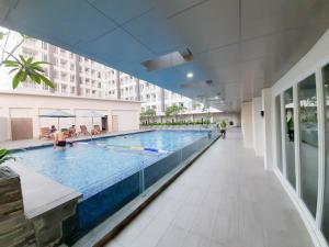 a large swimming pool in a large building at Apartemen Taman Melati Sinduadi By NGINAP in Sleman