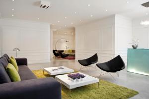 uma sala de estar com um sofá, cadeiras e uma mesa em Rochester Hotel M em Buenos Aires