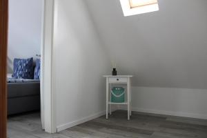 a small white table with a vase on it next to a bed at Op'n Dörp Apartments in Barsbek