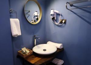 a blue bathroom with a sink and a mirror at Fuego Design Suites in Istanbul +97 photos