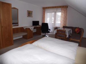 a bedroom with a bed and a desk with a computer at Ferienwohnung ENZTALPERLE in Enzklösterle