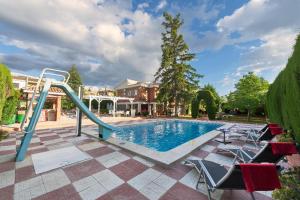 einen Pool mit Rutsche und Stühlen im Hof in der Unterkunft NEW. LUXURY VILLA C&C. JARDÍN, PISCINA Y BARBACOA in Granada