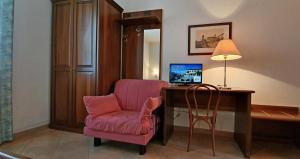 Cette chambre dispose d'une chaise et d'un bureau avec un ordinateur. dans l'établissement Villa Nencini, à Volterra