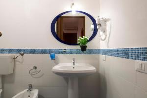 a bathroom with a sink and a mirror and a toilet at Casa Cavour sul Mare in San Vito lo Capo