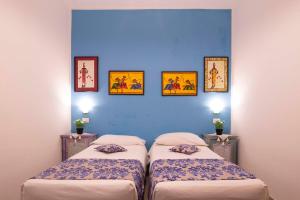 two beds in a room with a blue wall at Casa Cavour sul Mare in San Vito lo Capo