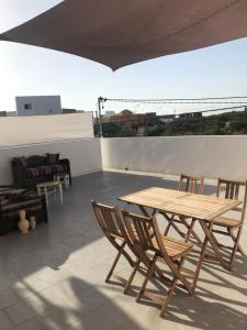 a wooden table and chairs on a roof at résidence les oliviers in Soliman