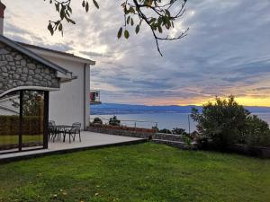 a house with a patio with a view of the water at Apartments Villa Cerić in Lovran