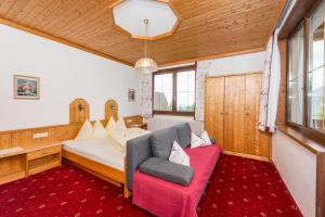 a bedroom with a bed and a couch and a chair at Gasthof Hunerkogel in Ramsau am Dachstein