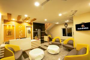 a waiting room with couches and chairs and a sign at Ponnis Hotel in Palani
