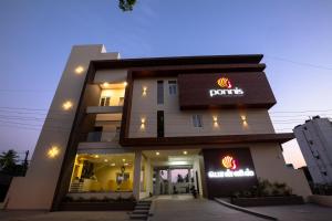 帕拉尼Ponnis Hotel的建筑正面景色,上面有陶器标志