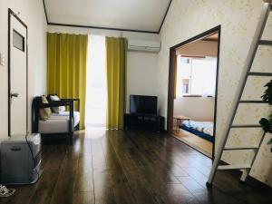 a room with a mirror and a bed and a television at 201Keiko's Home 大空間2LDKロフト付きfree parking in Kasugabaru