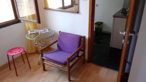 a purple chair and a glass table in a room at HappY ApartmenT Dubrovnik centre-free parking in Dubrovnik