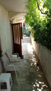 a patio with chairs and tables on a stone walkway at HappY ApartmenT Dubrovnik centre-free parking in Dubrovnik