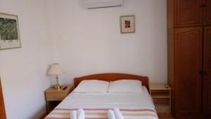 a bedroom with a bed with a wooden headboard at HappY ApartmenT Dubrovnik centre-free parking in Dubrovnik