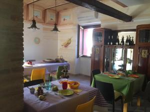 a dining room with two tables with green table cloth at Tenuta Porello in Rocca San Giovanni