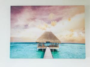 a pier in the ocean with a thatched building at 201Keiko's Home 大空間2LDKロフト付きfree parking in Kasugabaru