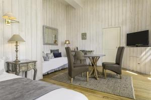 CondeauにあるDomaine De Villerayのベッド、テーブル、椅子が備わるホテルルームです。