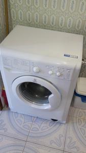 uma máquina de lavar roupa branca sentada num quarto em Rodzinny dom. em Augustów