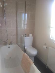 a bathroom with a tub and a toilet and a shower at sunrise view in Trimingham