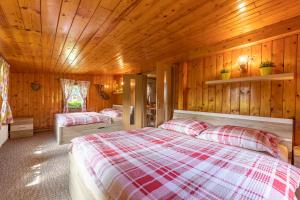 a bedroom with two beds in a wooden cabin at Chata HANA in Jeseník