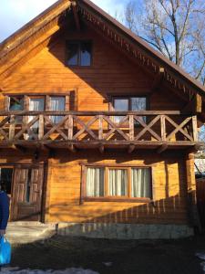 a wooden house with a fence on the side of it at Садиба Гуцульський Двір in Vorokhta