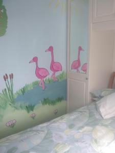 a bedroom with a mural of pink flamingos at sunrise view in Trimingham
