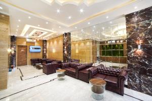 a lobby with brown leather couches and a wall of stone at Hotel Radana Vashi Navimumbai in Navi Mumbai