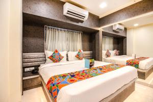 two beds in a room with two beds sidx sidx sidx sidx at Hotel Radana Vashi Navimumbai in Navi Mumbai