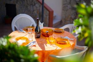 a table with a bottle of wine and glasses on it at Casa Cavour sul Mare in San Vito lo Capo