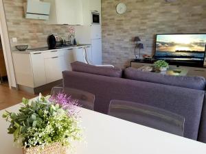 sala de estar con 2 sofás morados y cocina en Niebla Centro Apartamentos en Niebla