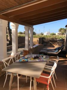 a patio with a table and chairs on a roof at Can Andreu Morna in Sant Francesc Xavier