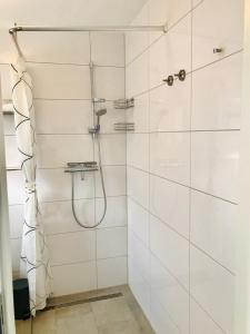 y baño con ducha de azulejos blancos. en SWEET HOME OUTLETCITY, en Metzingen