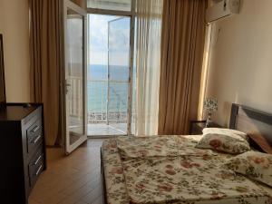 a bedroom with a bed and a view of the ocean at Beautiful House By the sea in Batumi