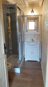 a bathroom with a glass shower and a sink at Rekreačné chaty Bedolandia in Veľký Slavkov