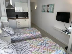 Habitación con 2 camas y TV. en Cozy Studio in Los Cristianos Beach FREE WIFI, en Arona