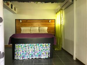 a bed with a wooden headboard in a room at Coconut Studio in Capesterre-Belle-Eau