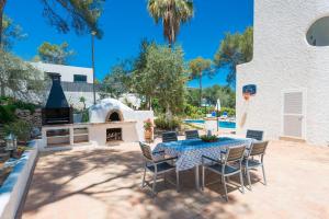 un patio con tavolo, sedie e camino di Villa LOS PINOS a Santa Ponsa