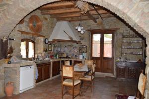 a kitchen with a table and chairs in a room at Sa Domu de sa Contissa in Sèlegas