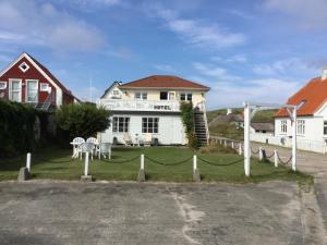 uma casa com uma cerca em frente em Hotel Vestkysten em Løkken