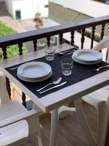 una mesa con platos y vasos en el balcón en Cozy Studio in Los Cristianos Beach FREE WIFI, en Arona